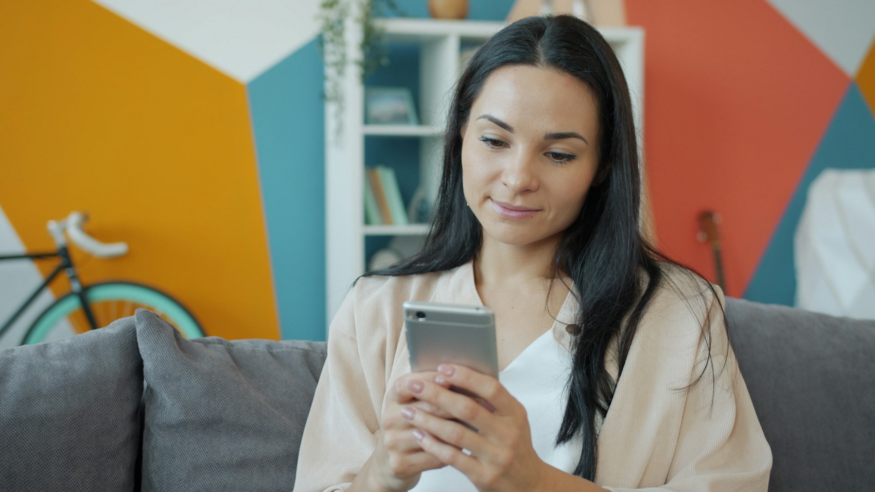 A woman on a sofa looking at her phone