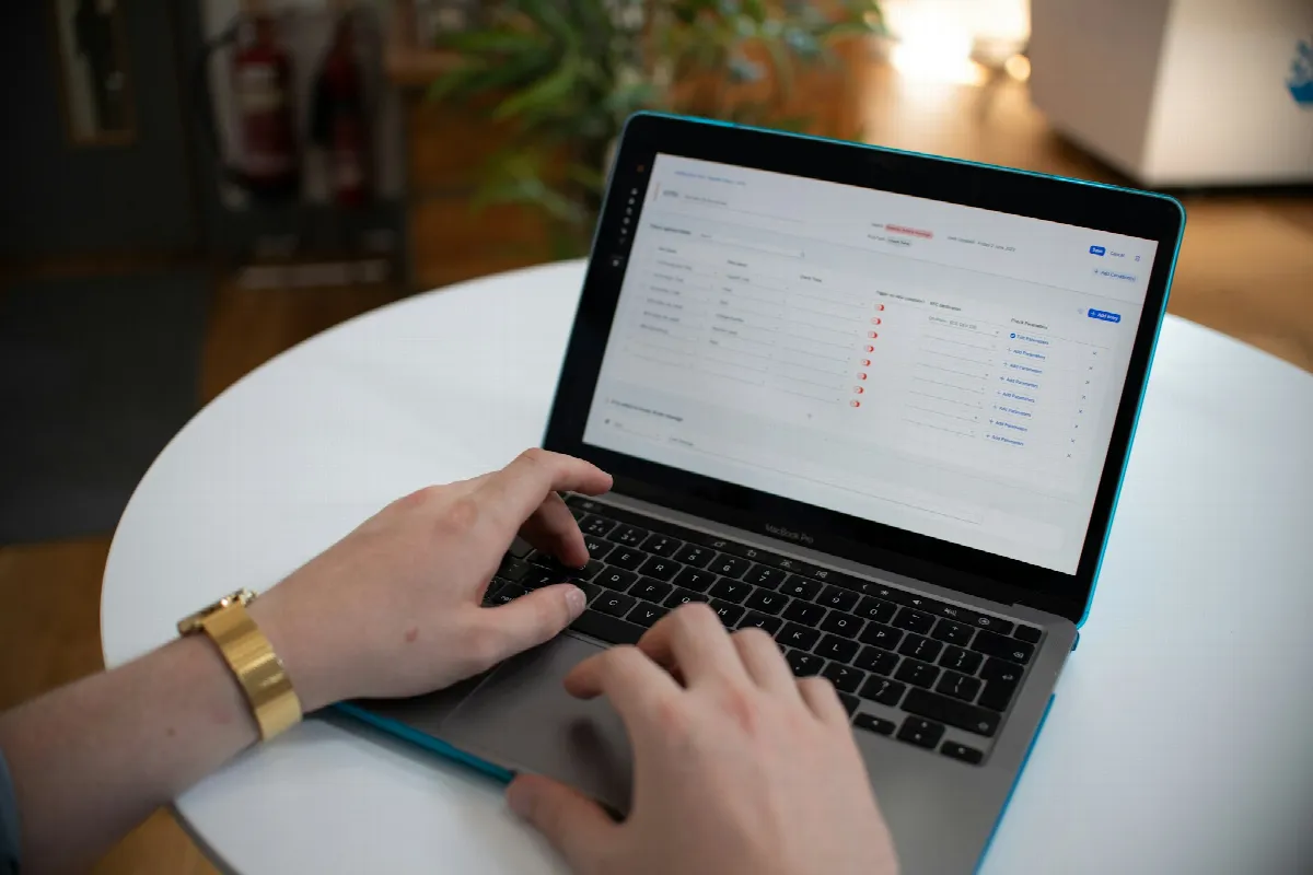 Hands typing on a laptop showing a spreadsheet of rows, the starting point for a bulk credit check