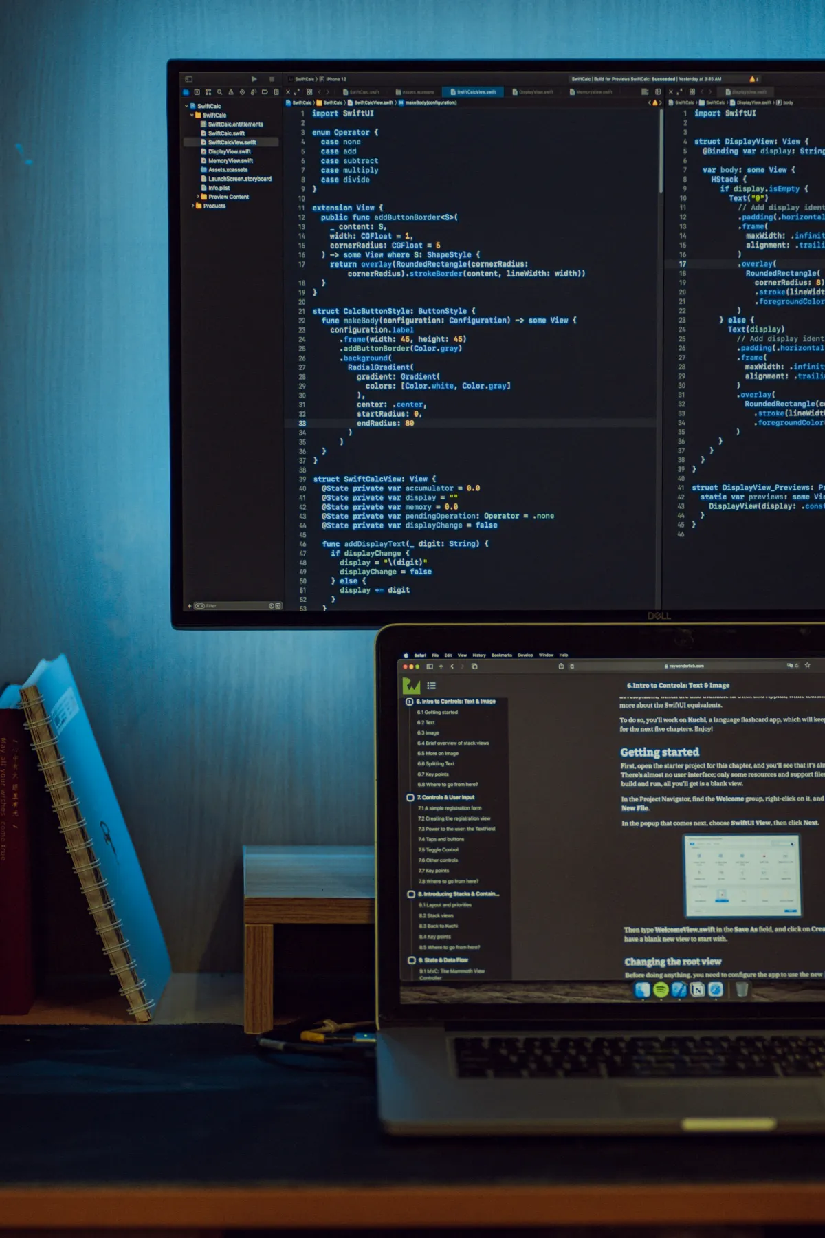 A monitor and laptop on a desk showing lines of code, the setup where a credit score API integration gets built